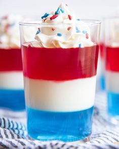 red, white and blue dessert in glasses with whipped cream on the top is ready to be eaten