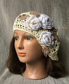 a mannequin head wearing a crochet hat with flowers