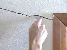 a person is working on an electrical wire that has been attached to the wall in front of them