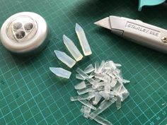 there are several pieces of glass on the table next to a knife and some cutters