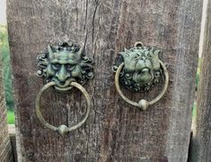 two metal lion heads are attached to the wooden door knobs on this old fence