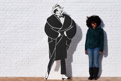 a woman standing next to a drawing of a man in a top hat and cane