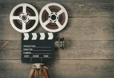 an overhead view of a film reel and clapper on a wooden background with planks