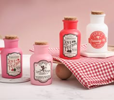 four bottles with labels on them sitting on a table