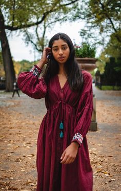 Romantic burgundy midi dress with dropped shoulder, drawstring around the waist for customized fit and cuffs adorned with patch of preloved Kutchi hand embroidery by the artisan of Kutch, Gujarat. Note: Embroidery patch (color and design) vary in each piece Handcrafted in India Bohemian Burgundy Dress For Fall, Bohemian Embroidered Midi Dress, Bohemian Midi Dress With Floral Embroidery For Fall, Bohemian Floral Embroidered Midi Dress For Fall, Bohemian Long Sleeve Burgundy Dress, Fall Bohemian Embroidered Cotton Dress, Long Sleeve Embroidered Dress For Fall Festival, Bohemian Long Sleeve Midi Dress With Embroidered Hem, Note Embroidery