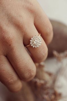 a person's hand with a diamond ring on it