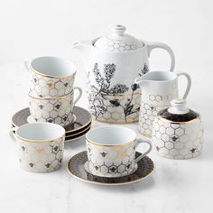 a white and black tea set with honeycombs on it