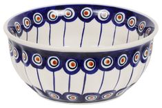 a blue and white bowl sitting on top of a table next to another bowl with an orange dot in the center