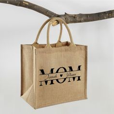 a bag hanging from a tree branch with the words mom and me printed on it