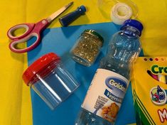 the contents of a school lunch laid out on a blue and yellow tablecloth with scissors