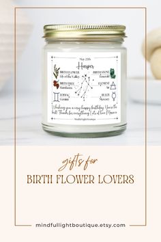 a candle with the words gifts for birth flower lovers written in gold and white on it