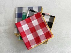 four napkins are stacked on top of each other in different colors and patterns,