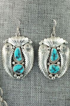 This vintage turquoise and sterling silver necklace and earrings set was made by Navajo silversmith Nora Tsosie. The back of the necklace is signed NT and stamped sterling. Please note this is a pre-owned piece, with patina, in vintage condition.Necklace: 28"Length: 2 1/8"Width: 1 3/4"Earrings:Length: 2 1/4"Width: 1 1/4"Free shipping on all orders! We ship with USPS and always include tracking. All orders ship within a day of payment.Returns are accepted up to 30 days after you receive your orde Elegant Turquoise Concho Jewelry, Artisan Collectible Jewelry With Matching Earrings, Artisan Jewelry With Matching Earrings For Collectors, Sterling Silver Turquoise Concho Jewelry, Traditional Turquoise Concho Jewelry, Traditional Turquoise Jewelry With Concho, Traditional Turquoise Jewelry Stamped 925, Traditional Silver Turquoise Concho Necklace, Traditional Silver Turquoise Necklace With Concho