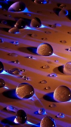 some water droplets are floating in the air and on top of each other, with blue lights behind them