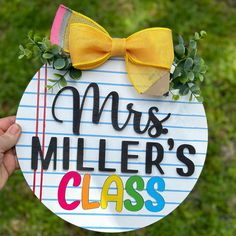 a hand holding up a sign that says mrs miller's class