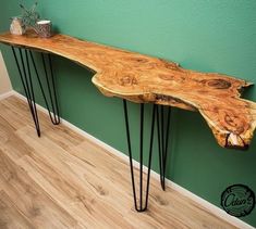 a wooden bench sitting on top of a hard wood floor next to a green wall