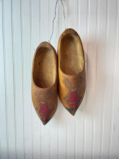 two wooden shoes hanging on a wall