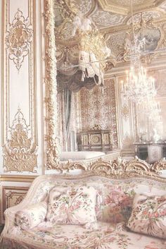 an ornately decorated room with chandelier, couch and mirror on the wall