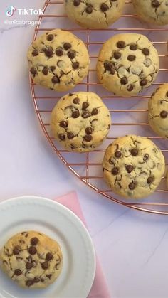 chocolate chip cookies cooling on a rack next to a white plate with a pink napkin