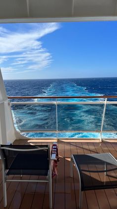 two lounge chairs on the deck of a cruise ship looking out at the blue ocean