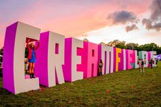 people are standing in the letters that appear to be made out of pink and white