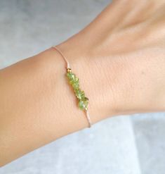 Peridot chips dainty string bracelet; simple string wish bracelet - Minimalist string bracelet with adjustable sliding closure. - Dainty gold filled sterling silver beads - Irregular tiny peridot chips. - Beige strong string. - A string bracelet is a symbolic gift to be offered to anyone, as a talisman to protect from negativity. - Ready to give it as a gift this bracelet comes wrapped in one nice jewelry bag. If you have any questions about this item please feel free to leave a message. If you Adjustable Minimalist Beaded Bracelets For May Birthstone, Adjustable Delicate May Birthstone Jewelry, Adjustable Peridot Bracelets For Gifts, Adjustable Peridot Bracelet, Black Tourmaline Jewelry, Black Tourmaline Bracelet, Peridot Bracelet, Nice Jewelry, Peridot Jewelry