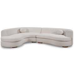 the curved sectional sofa is made from white fabric and has two pillows on each side