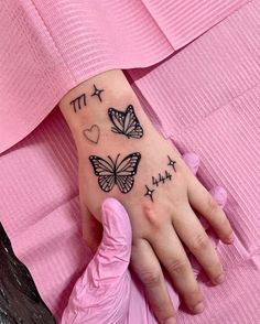 a woman's hand with two butterflies on it and the words ttt written in black ink