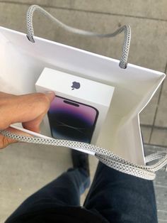 someone is holding an apple product in their hand and it's inside the bag