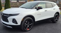 a white chevrolet suv parked in a parking lot