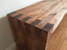 a large wooden table sitting on top of a hard wood floor next to a wall