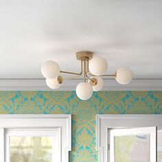 a chandelier hanging from the ceiling in a room with green and blue wallpaper