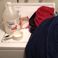 a white washer sitting on top of a dryer next to a blue towel