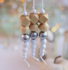 a close up of a mobile with beads hanging from it's sides and wood beads attached to the strings