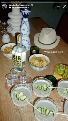 the table is set up with many dishes and glasses on it, including cucumbers