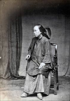 an old photo of a woman sitting on a chair