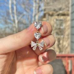 someone is holding three small diamond earrings in their left hand and the other one has two smaller diamonds on it