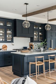 a kitchen with dark blue cabinets and wooden floors