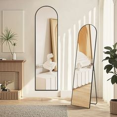 a mirror sitting on top of a wooden floor next to a plant in a room