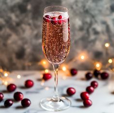 a wine glass filled with champagne and cranberries