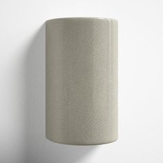 a white wall light hanging on the side of a wall next to a lamp shade