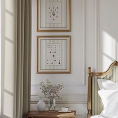 two framed pictures hang on the wall above a bed with white sheets and pillows in a bedroom