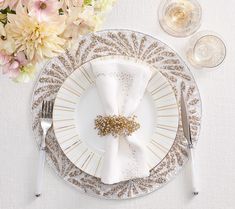 a white and gold place setting with flowers