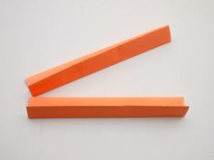 two orange pieces of paper sitting on top of each other