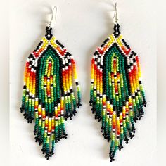 a pair of colorful beaded earrings on a white background