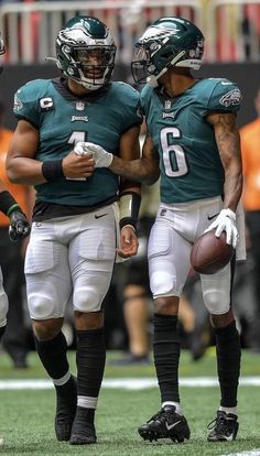 two philadelphia eagles players standing next to each other