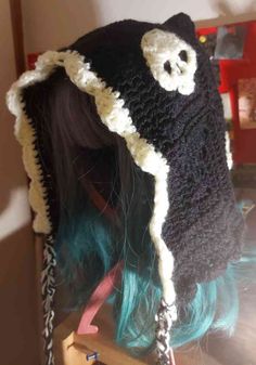 a woman with long hair wearing a black and white crochet hat on top of her head