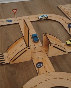 a wooden toy car track with cars on it