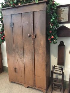 an old wooden armoire sitting next to a chair