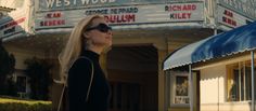 a woman standing in front of a movie theater